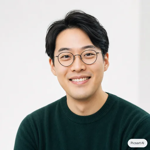 GPT Image 2: headshot for a startup team page, man in his thirties, East Asian, round glasses, dark green sweater, light background, warm smile